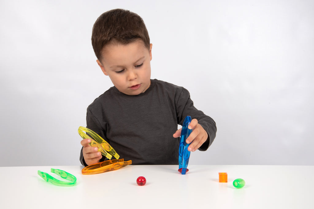 Translucent color tweezers in yellow and blue, child holding a tweezer tool.