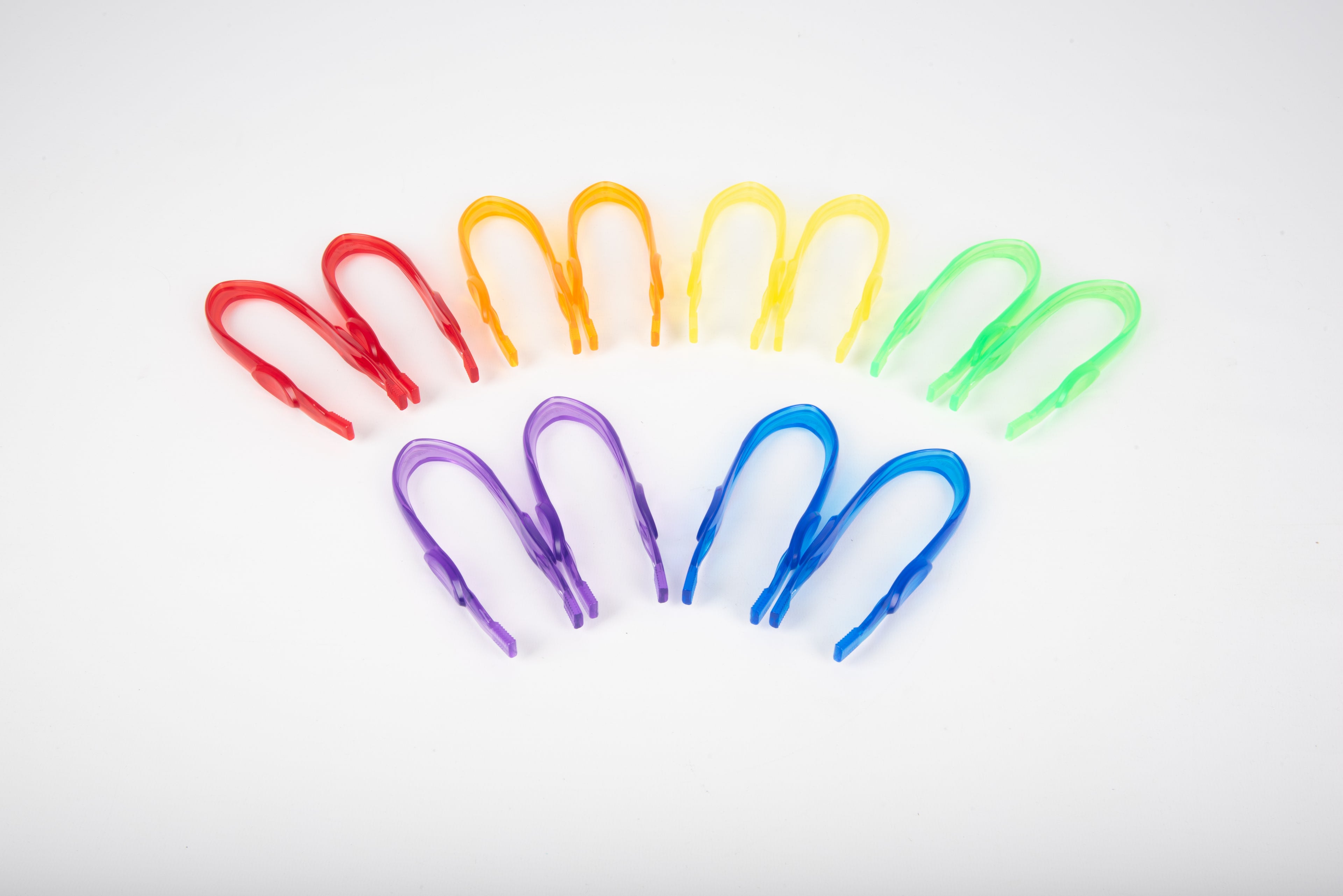Translucent color tweezers set with purple, blue, green, and red grips fanned.