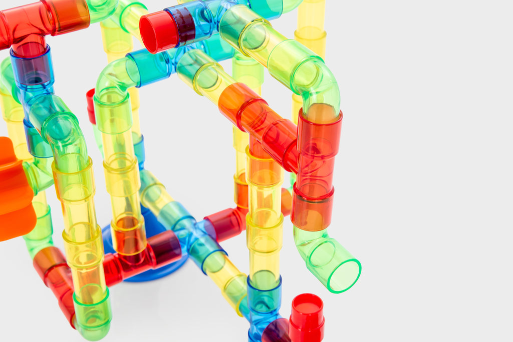 Translucent water pipe toy close-up of connected green, red, and blue tubes