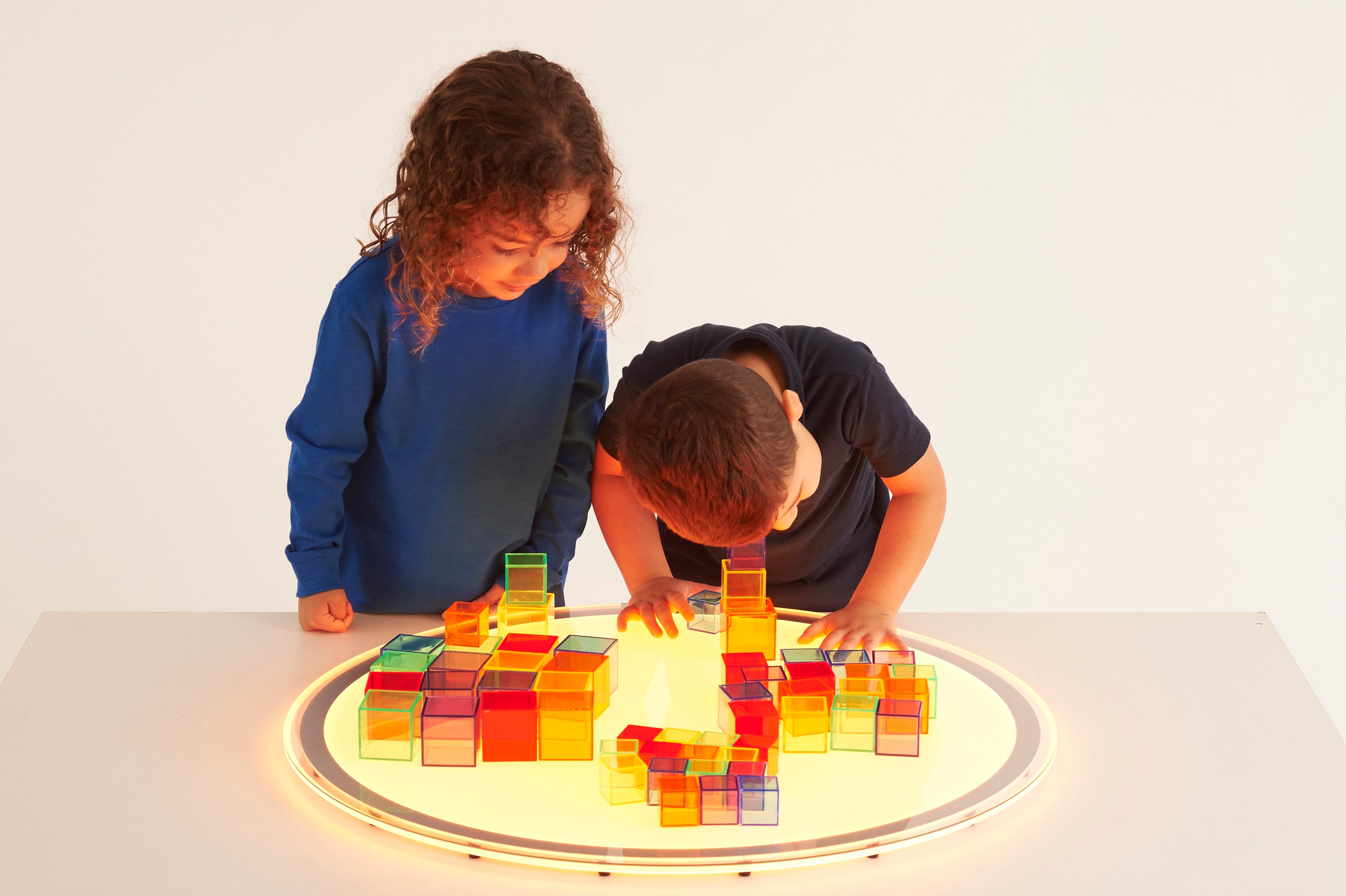 Translucent building cubes set, kids building on a glowing circular base