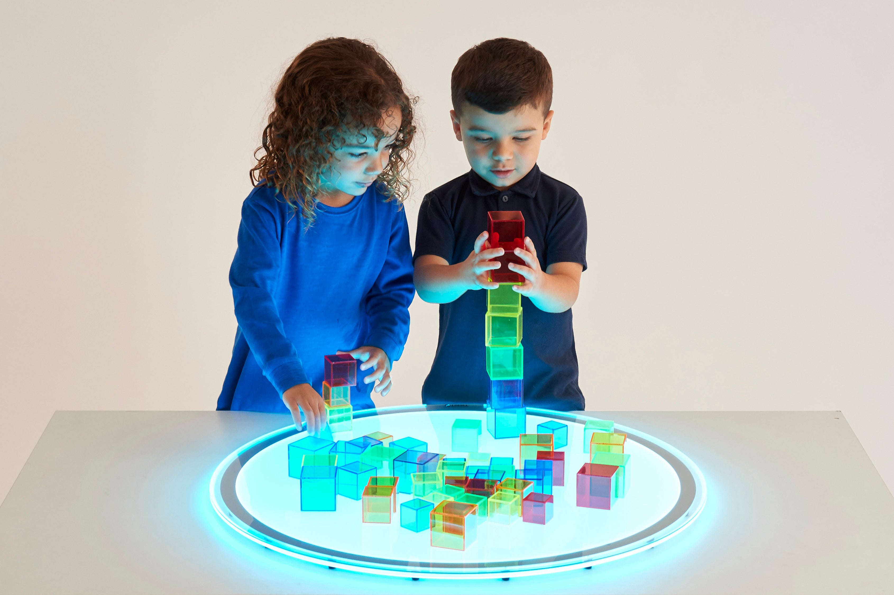 Translucent building cubes set, kids arranging translucent cubes under a light ring
