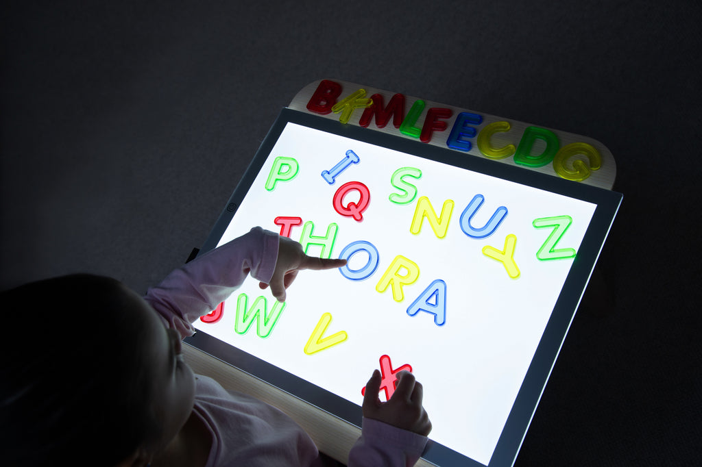 Translucent uppercase letters on illuminated letter board, colorful A–Z shapes