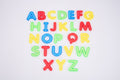 Colorful translucent uppercase alphabet letters A–Z on white surface, spaced layout