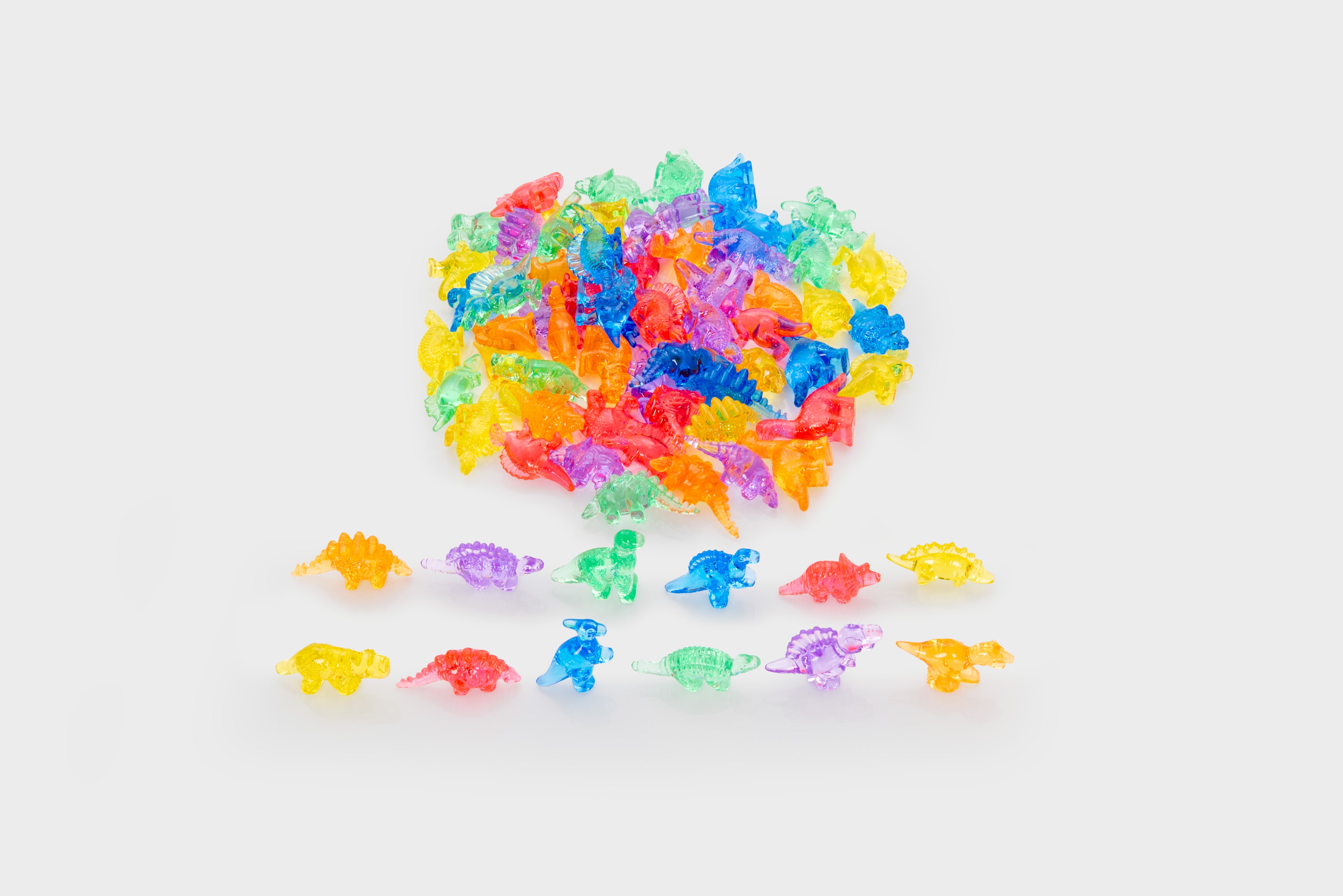 Translucent multicolor dinosaur figurines scattered, with a few pieces grouped.