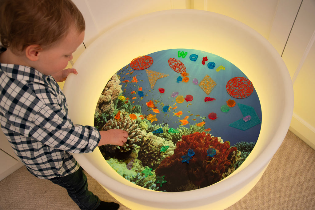 Under the Sea discovery play mat with underwater graphic and child viewing the screen