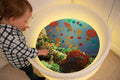 Under the Sea discovery play mat with underwater graphic and child viewing the screen