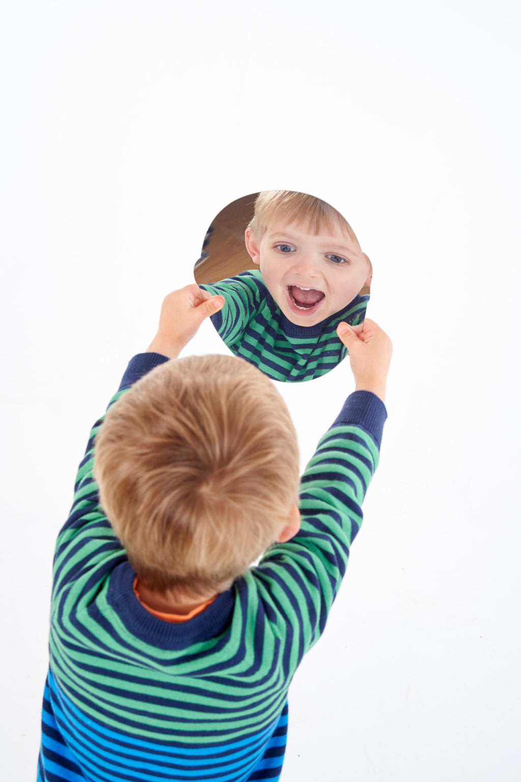 Child holding a black-and-white emotion face card with a big smiling expression