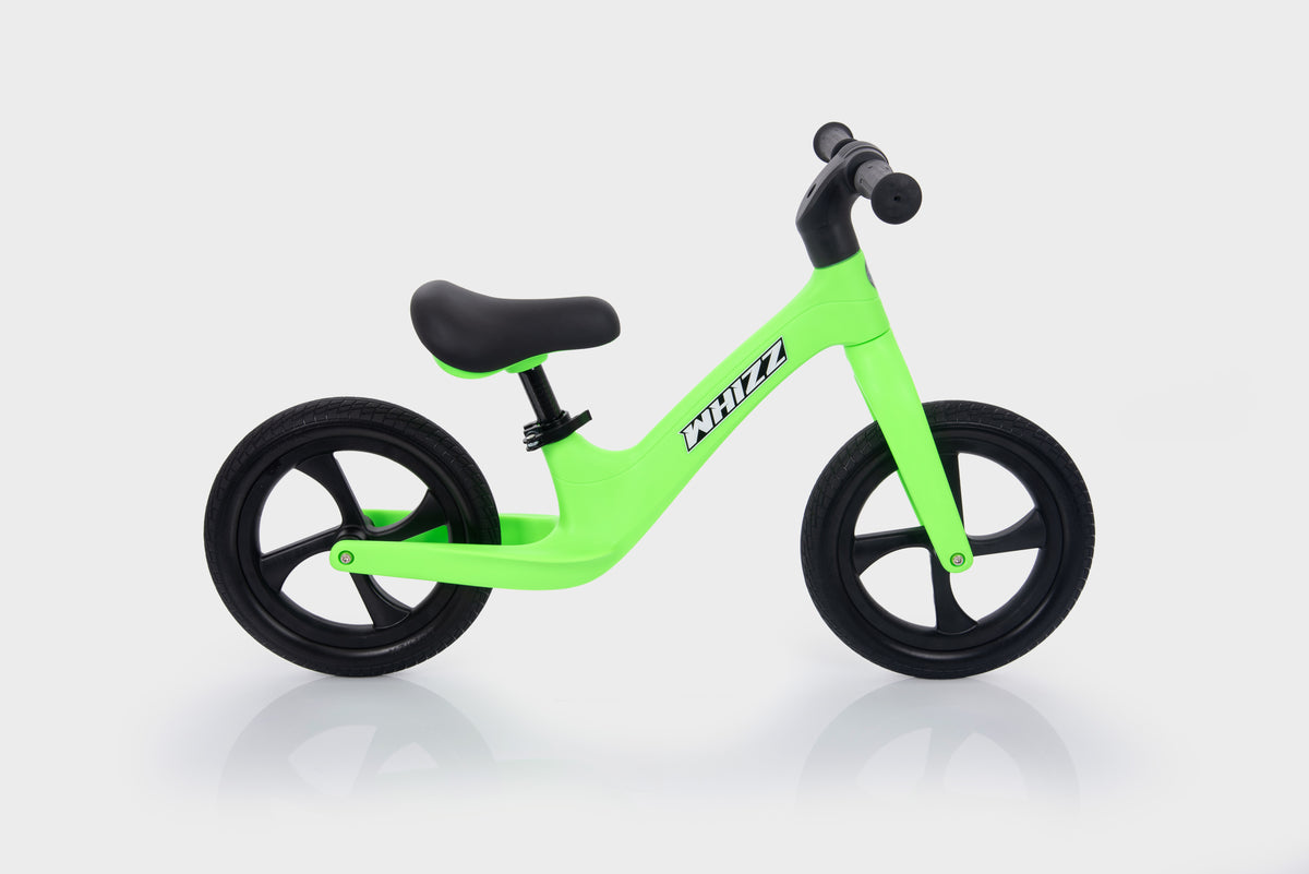 Bright green balance bike with black wheels and padded black seat