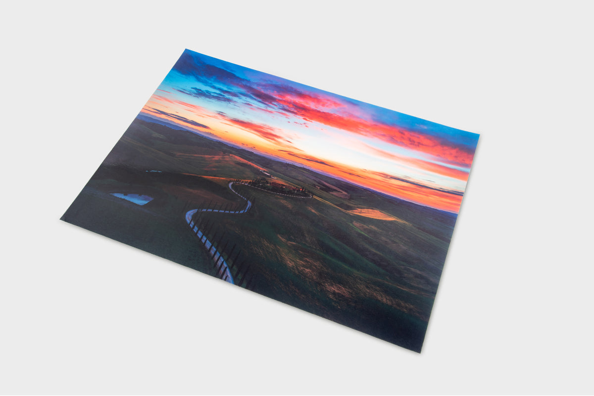 Winding road play mat with sunset sky artwork, dark highway and surrounding landscape