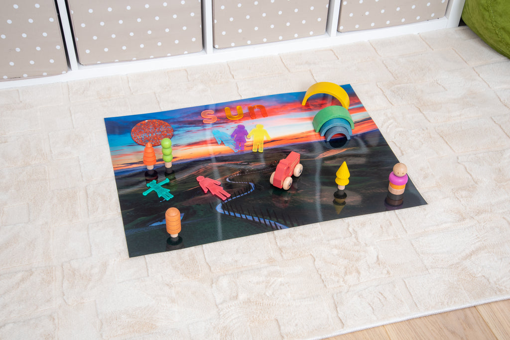Play mat with colorful rainbow arch, winding road and fence, small toy animals