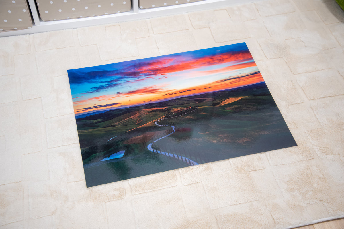 Winding road play mat showing orange-blue sunset and curving highway through fields
