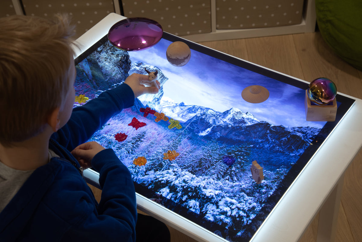 Child playing on winter play mat with glowing dome and planet accessories