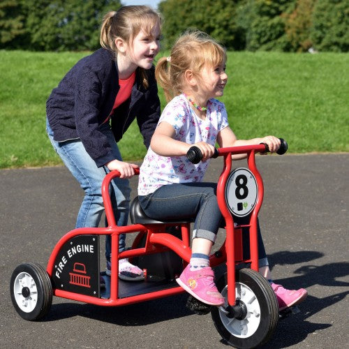 Red kids ride-on fire engine tricycle with black seat and number 8 panel.