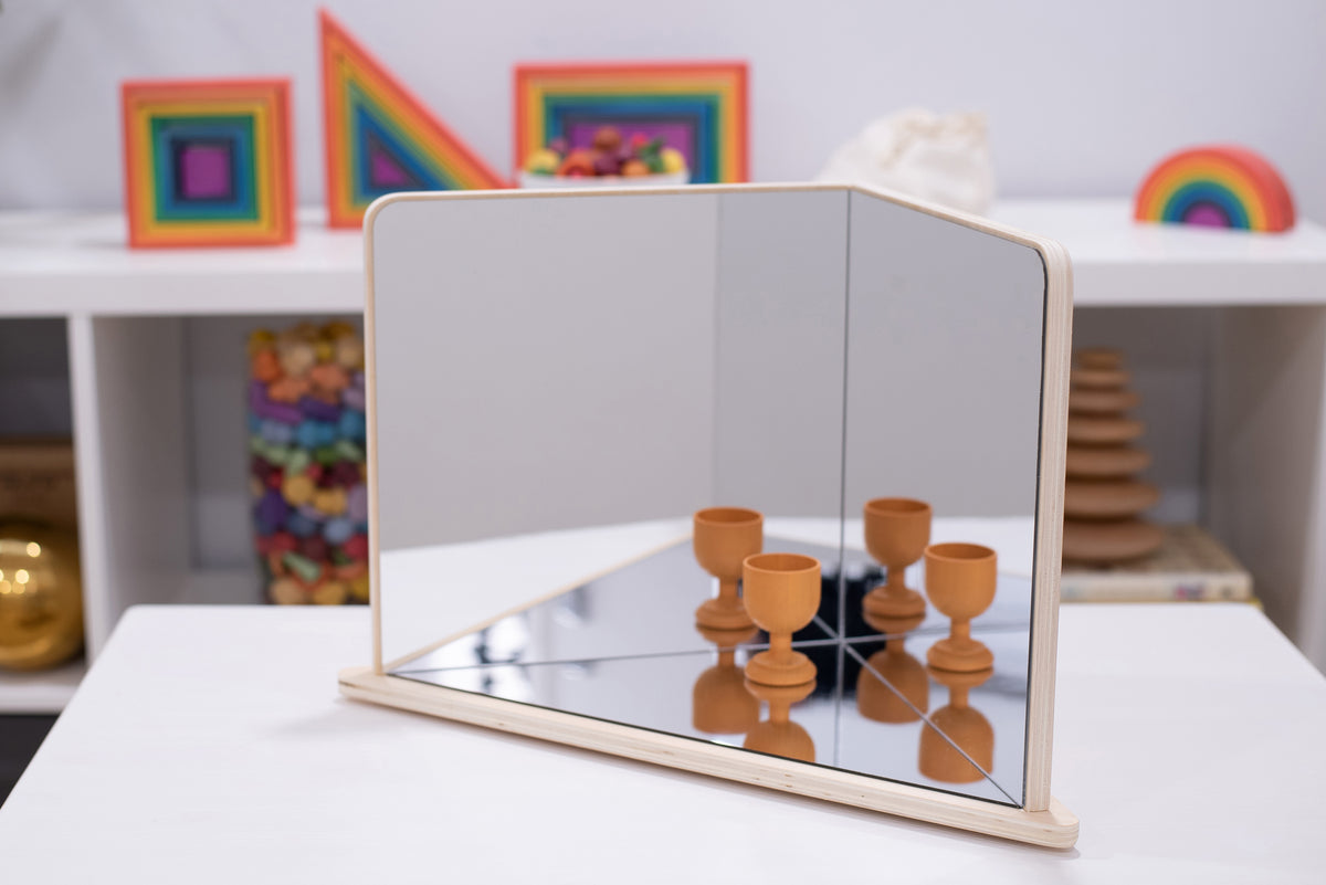 Wood-framed 4-way mirror reflecting brown candlestick-style pieces