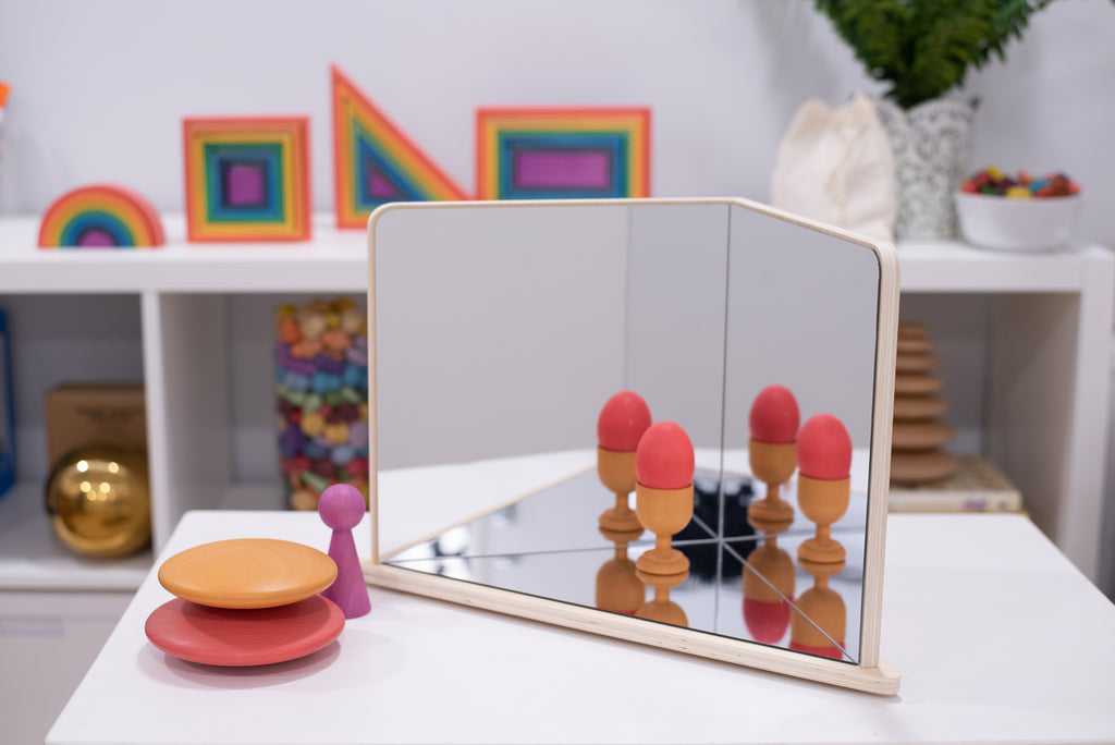Wood-framed 4-way mirror reflecting pink and brown toy figures