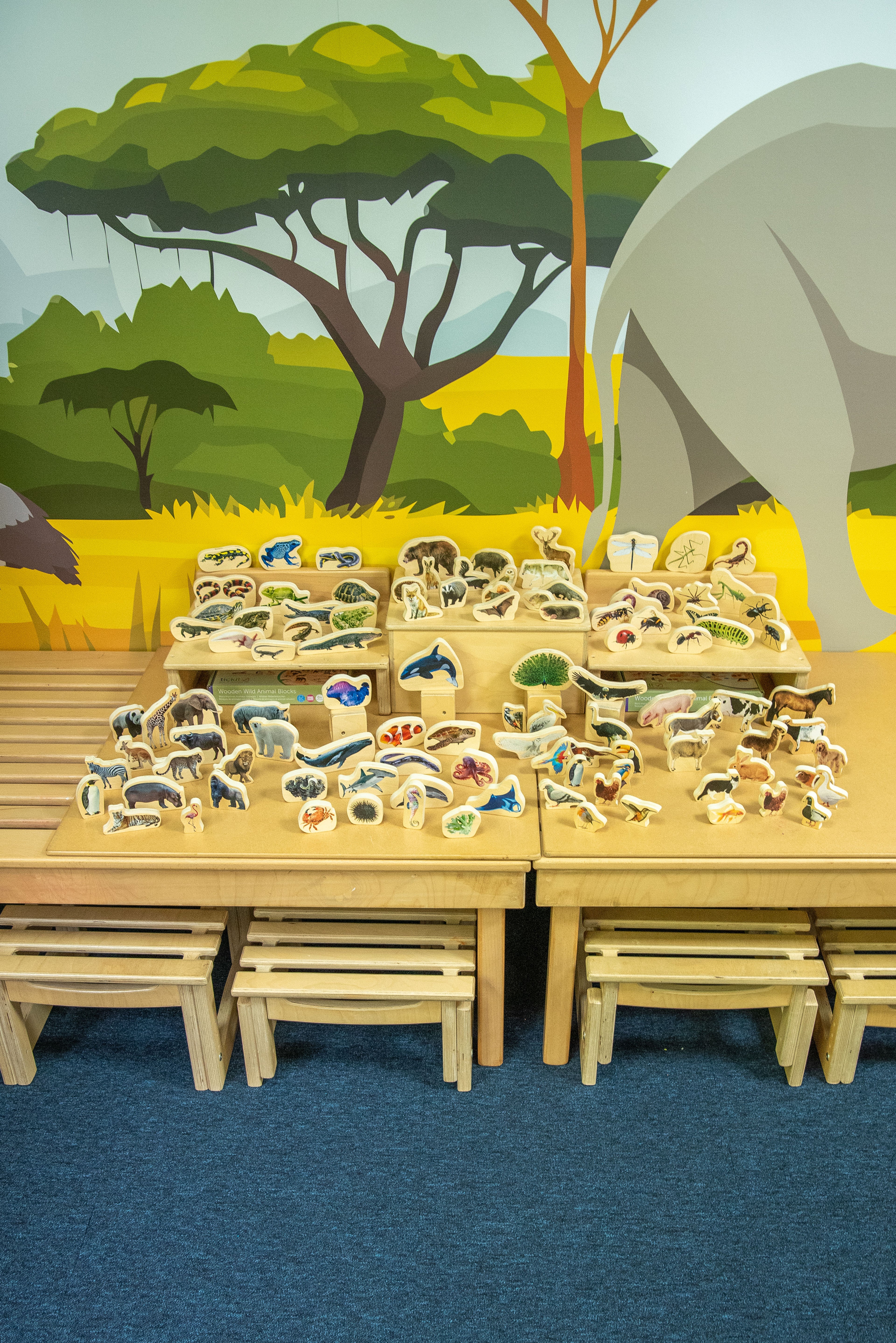 Wooden animal block set with many carved animal figures on display table