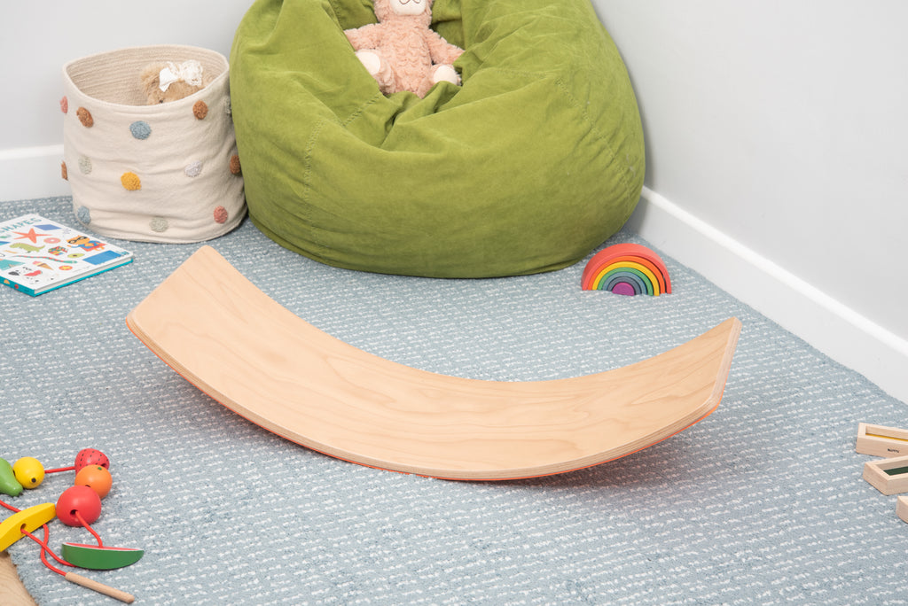 Light wood curved balance board with orange side, crescent rocking design