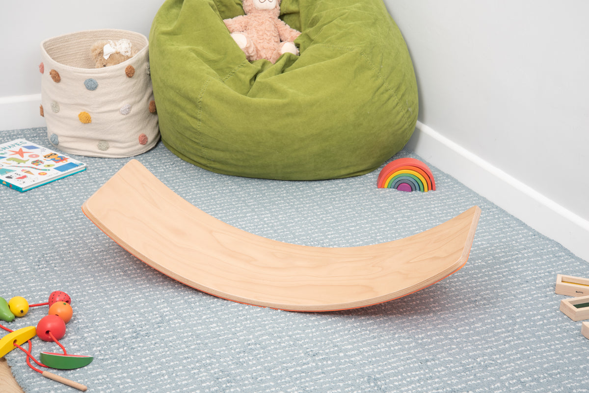 Light wood curved balance board with orange side, crescent rocking design