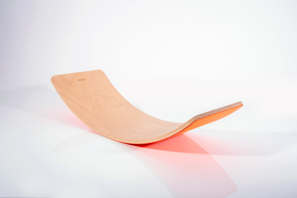 Wooden crescent balance board with smooth curved surface and orange edge