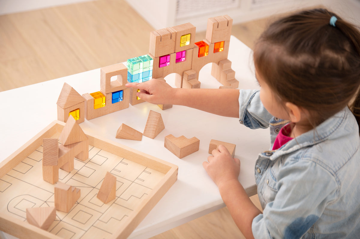 Wooden gem building block set with a child placing blocks on a table