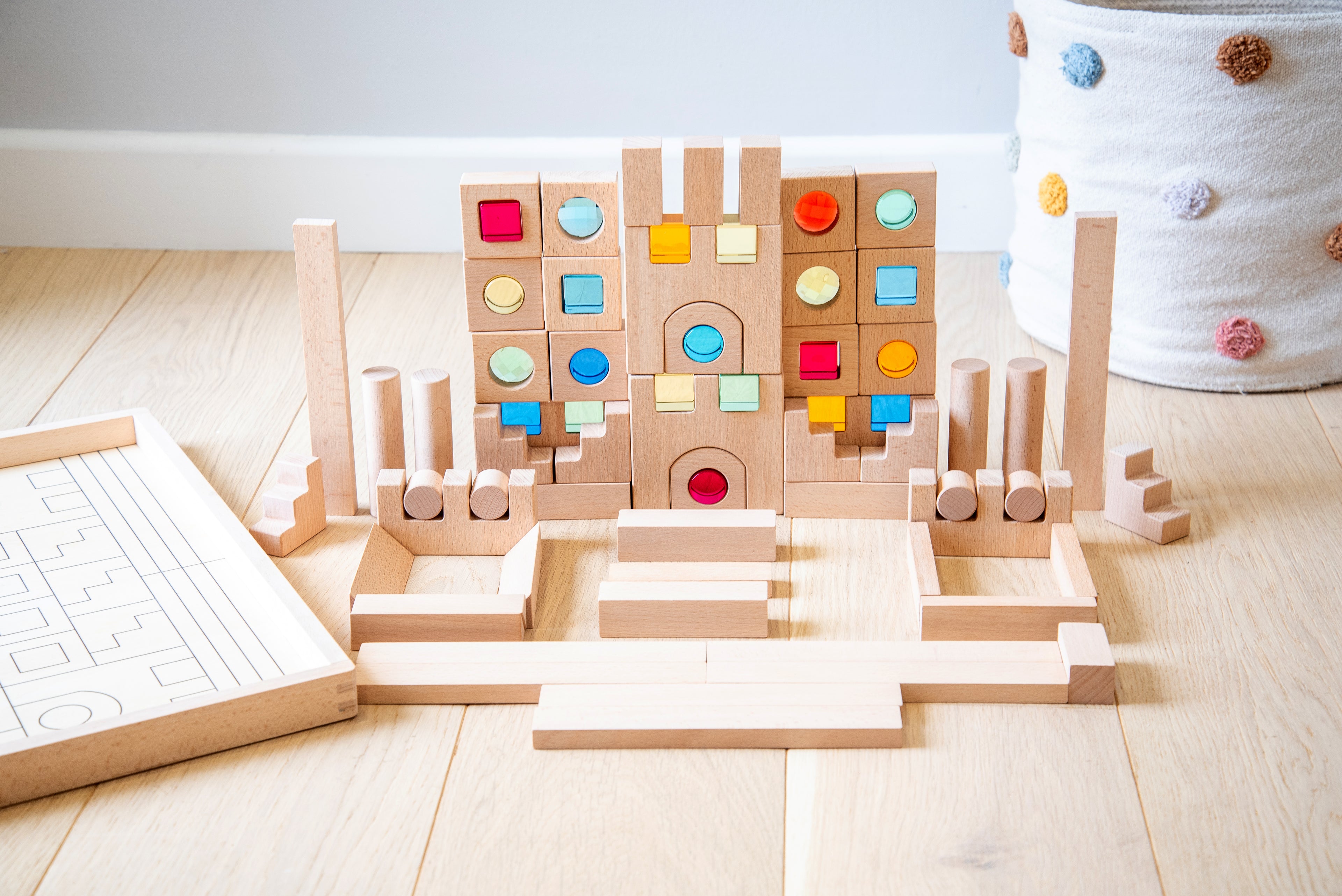 Wooden gem building blocks playset with stacked walls and multicolor circular gems.