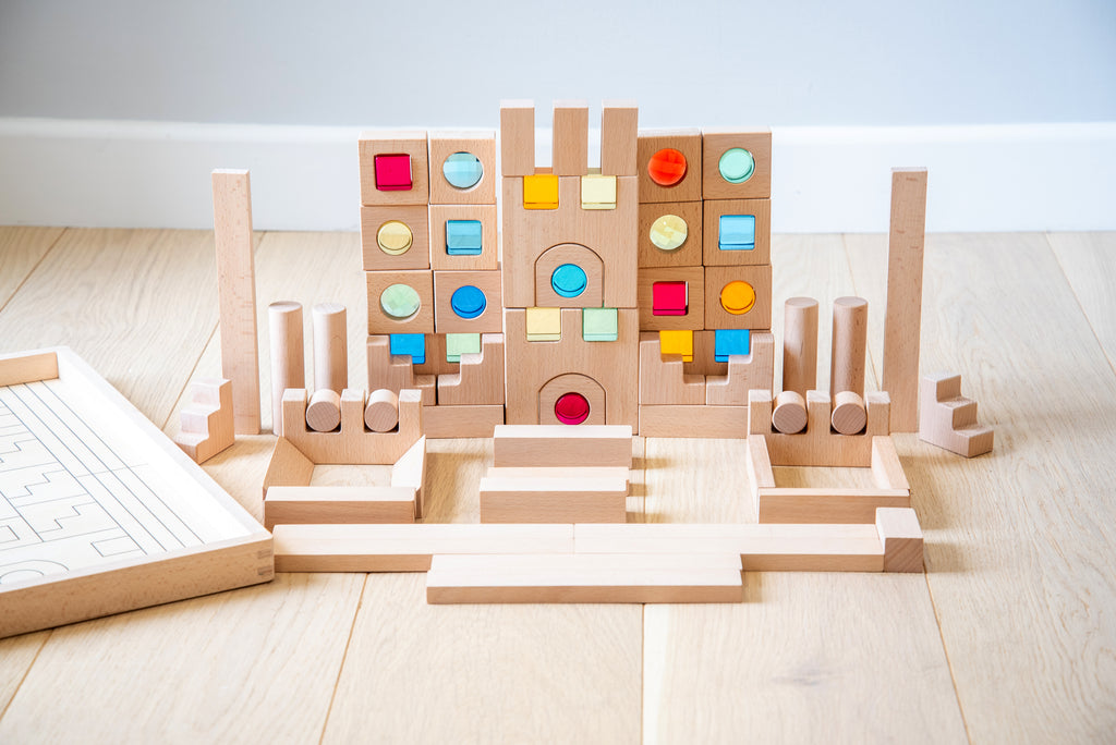 Wooden gem building blocks playset with multicolor gem insets and central arch.