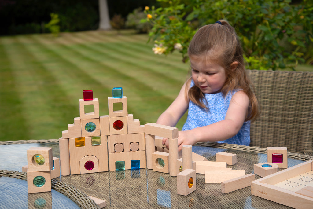 Wooden gem building blocks set with colorful inset pieces, arranged for play.
