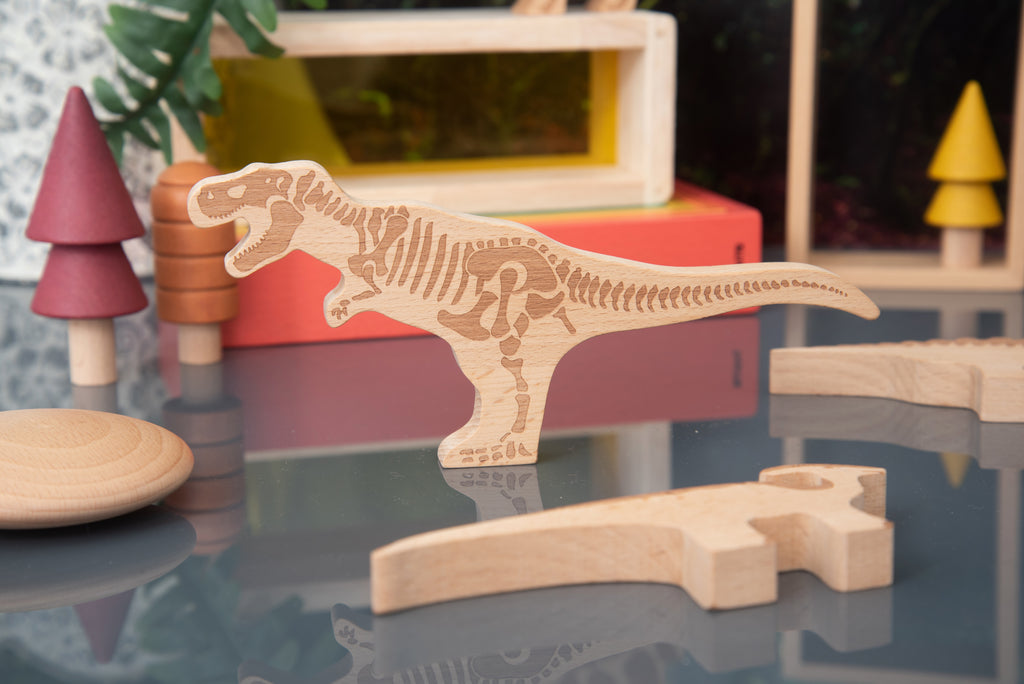 Wooden dinosaur block with head and tail, light wood with engraved skeleton details
