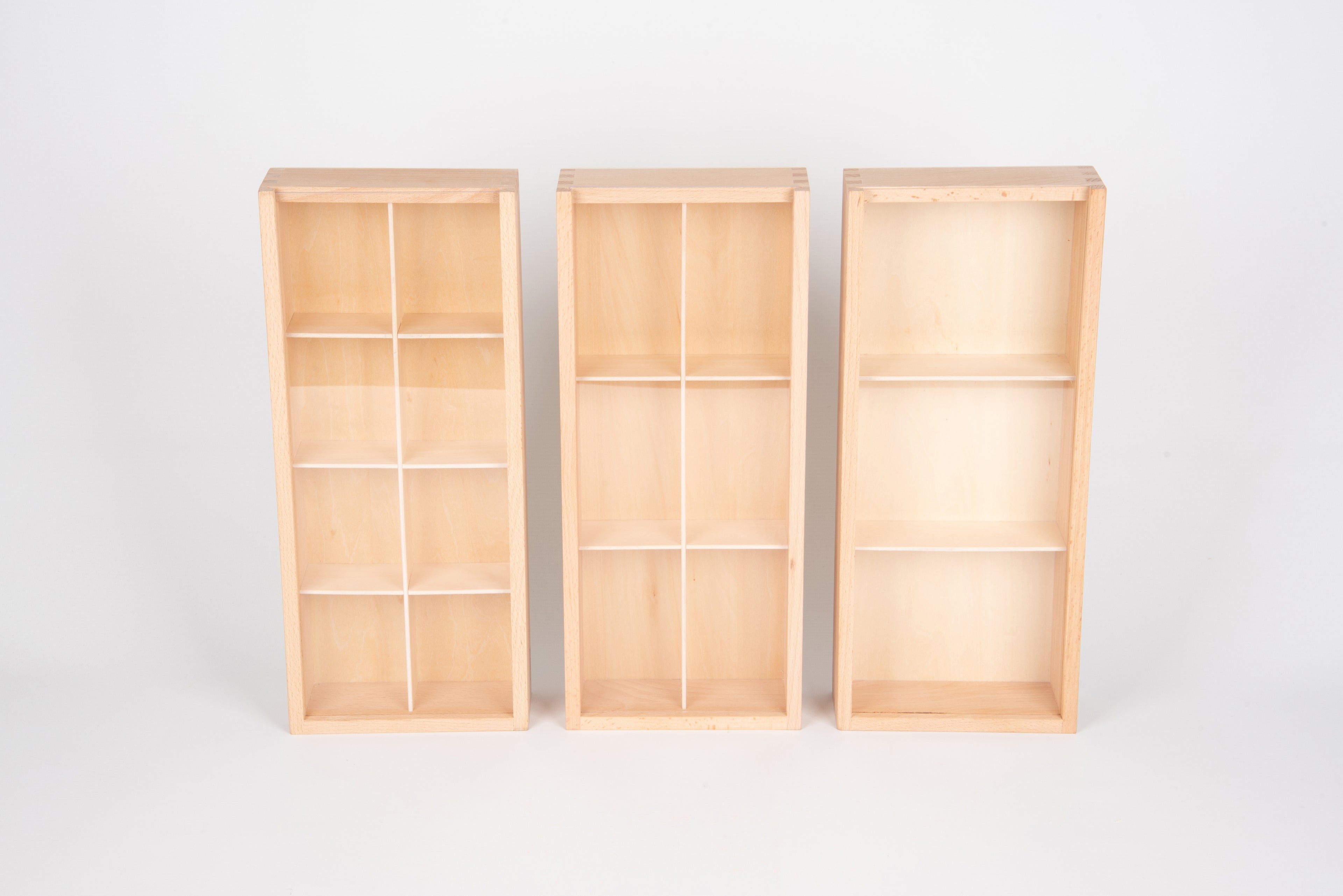 Three upright wooden storage boxes with grid compartments, empty