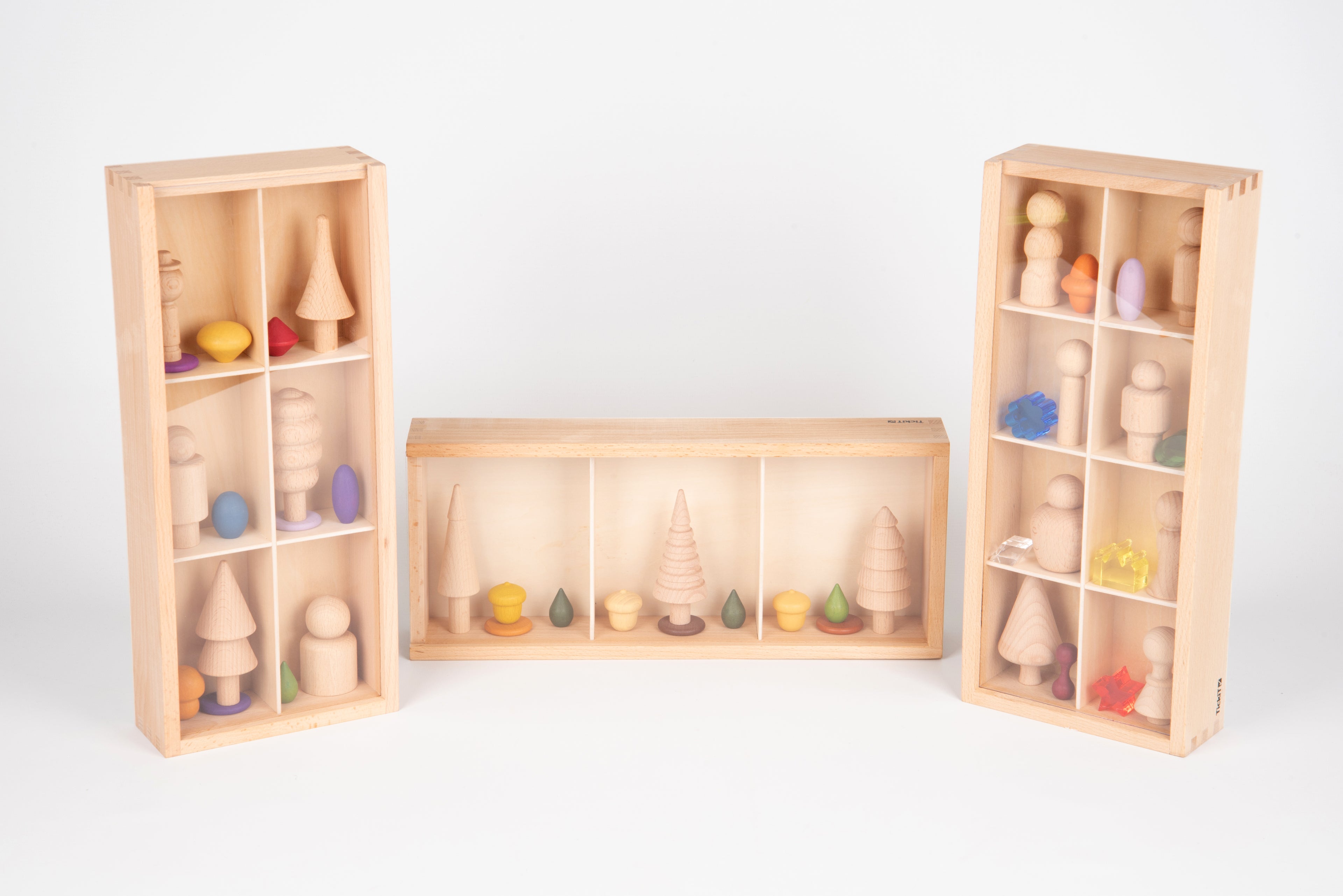 Wooden discovery box set with open side cabinets and center tray, filled with pieces