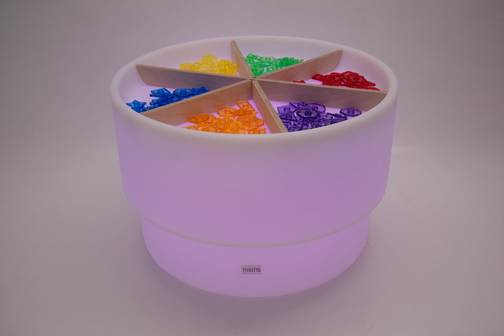 Light wood divider cross inside lilac round storage bin with multicolor blocks
