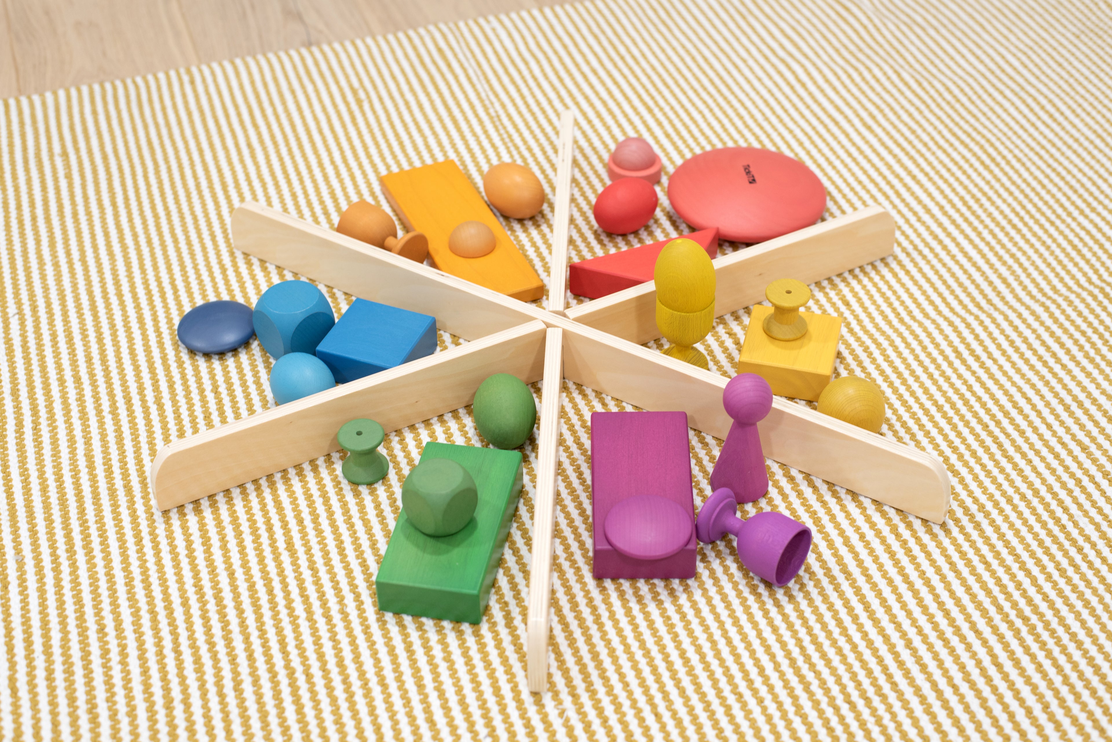 Light wood star divider with colorful foam blocks on striped fabric surface