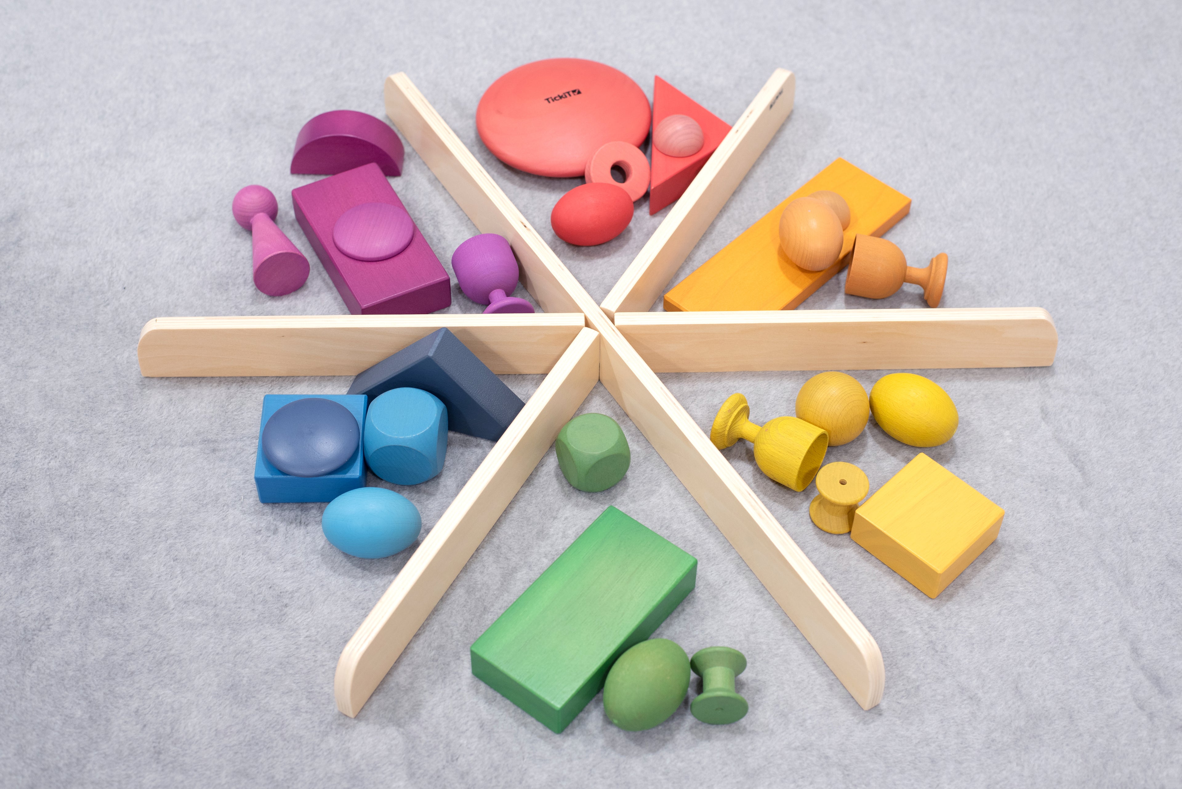 Light wood star divider with colorful foam blocks and shapes on gray surface