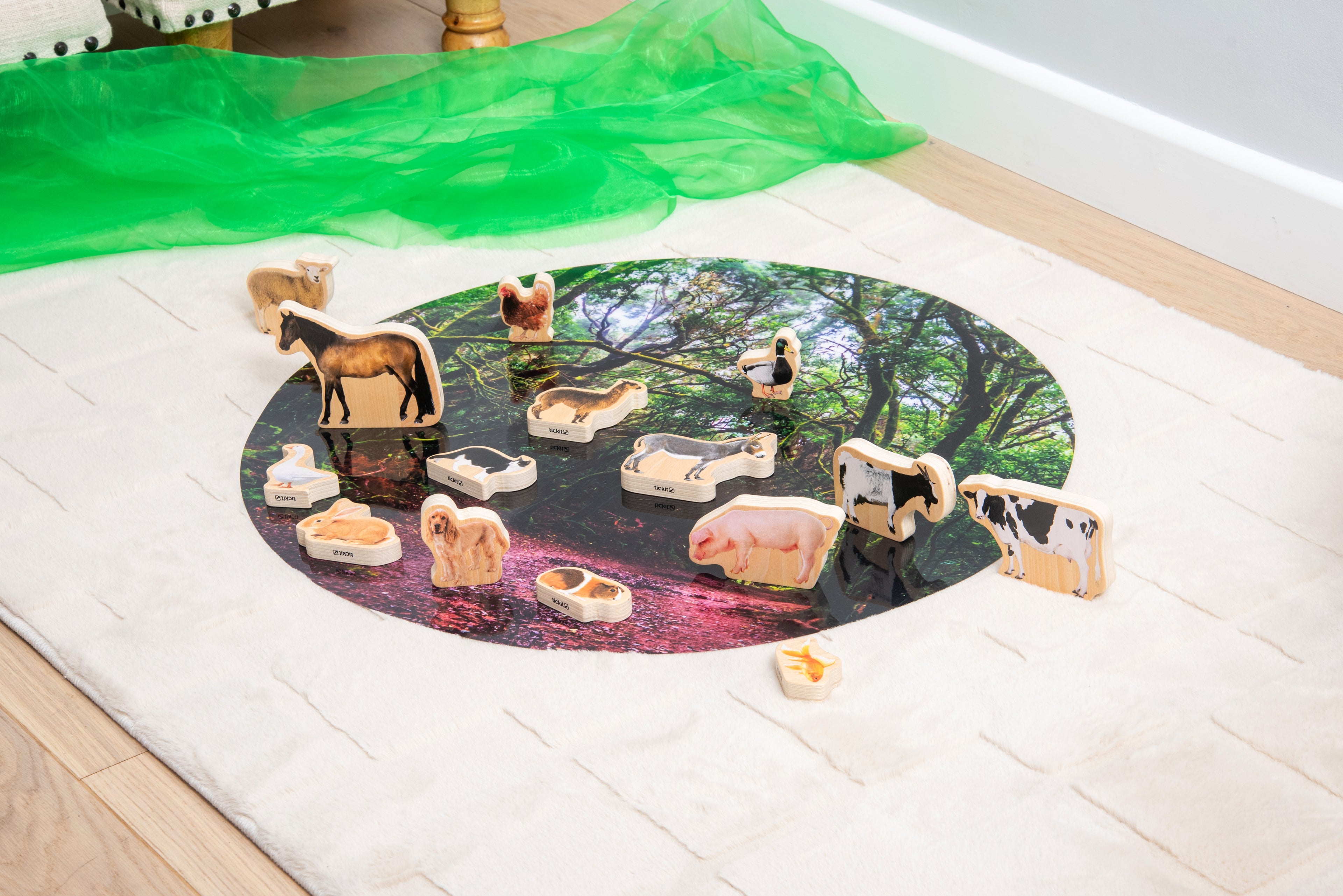 Wooden domestic animal blocks on a round nature scene play mat