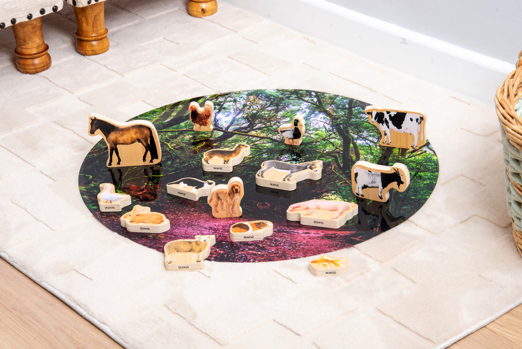 Wooden domestic animal blocks on an oval nature scene play mat