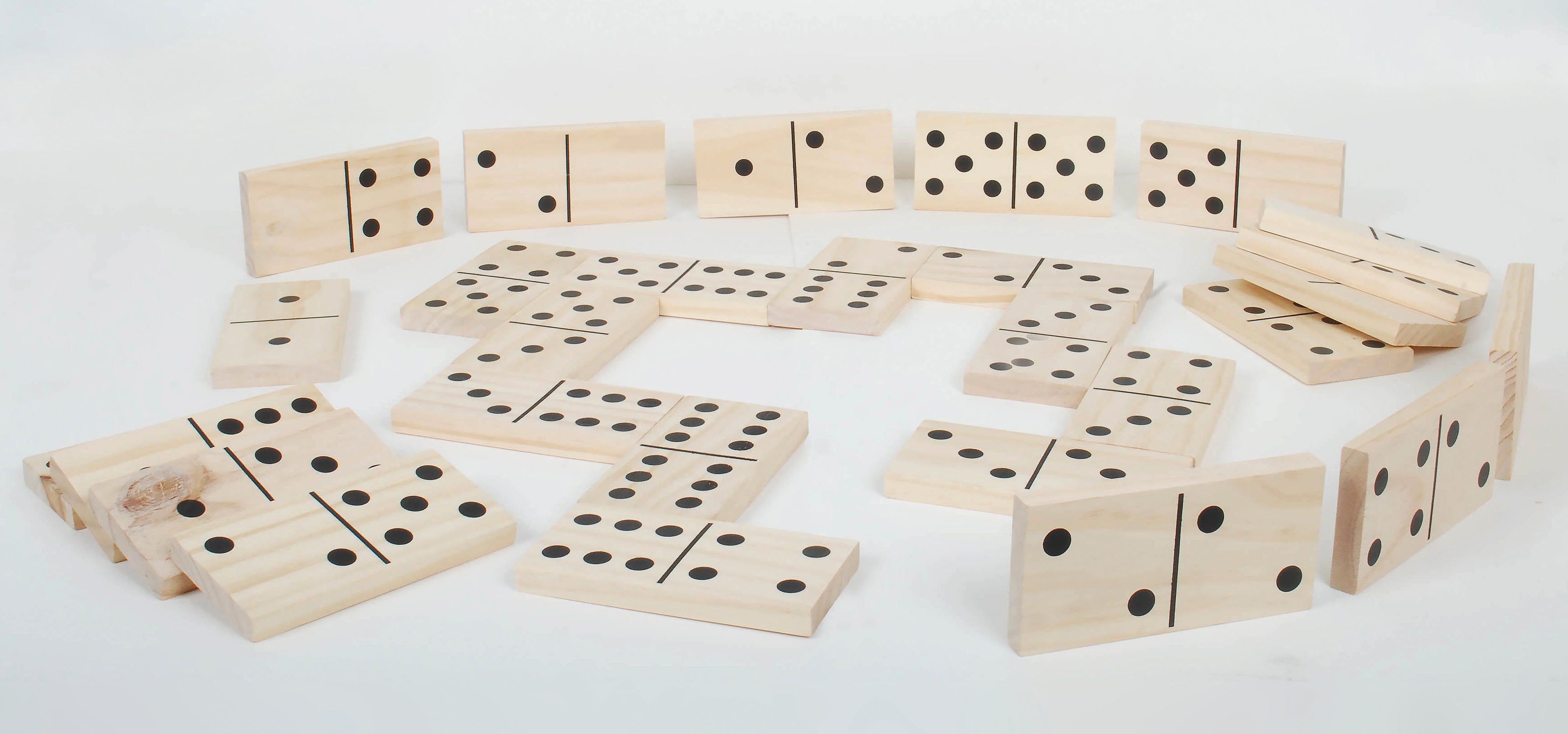 Wooden domino tile set scattered on a flat surface, showing black dot pips