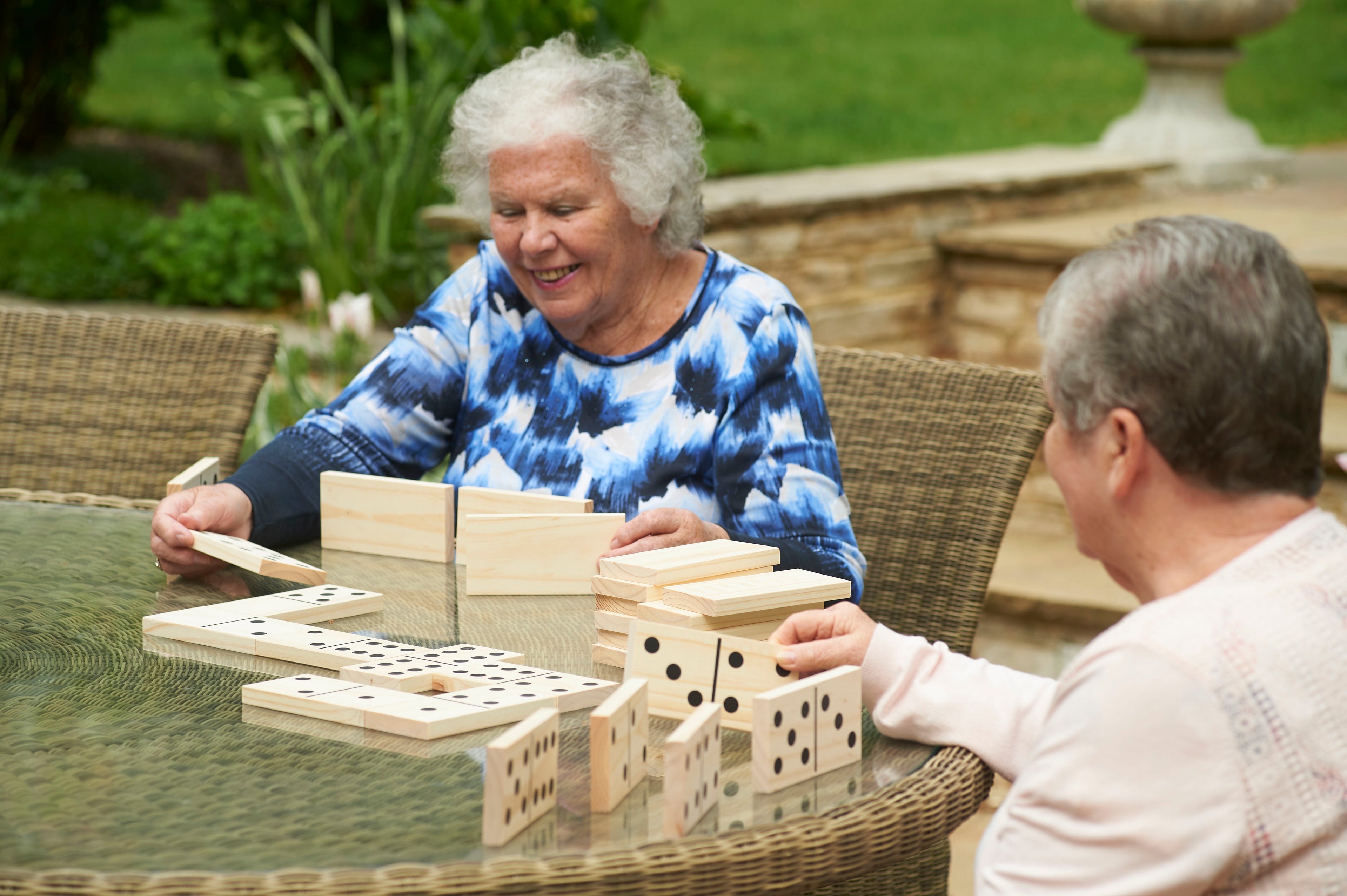 Wooden domino tile set with black dot pips, being arranged during play