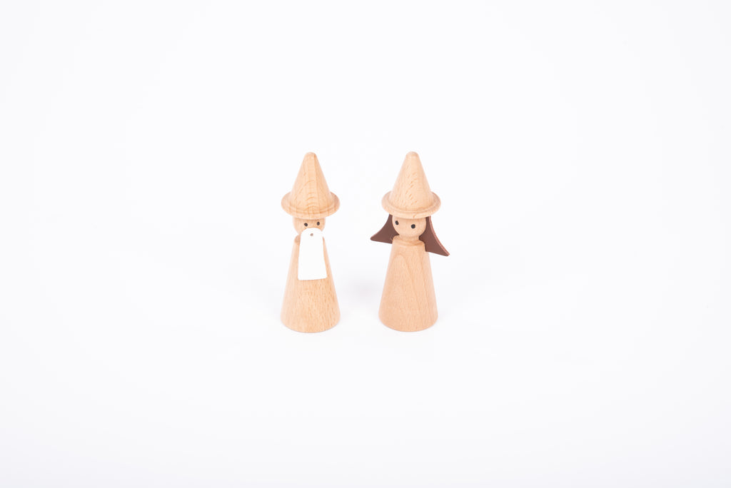 Two wooden wizard figures with cone hats and light wood bodies