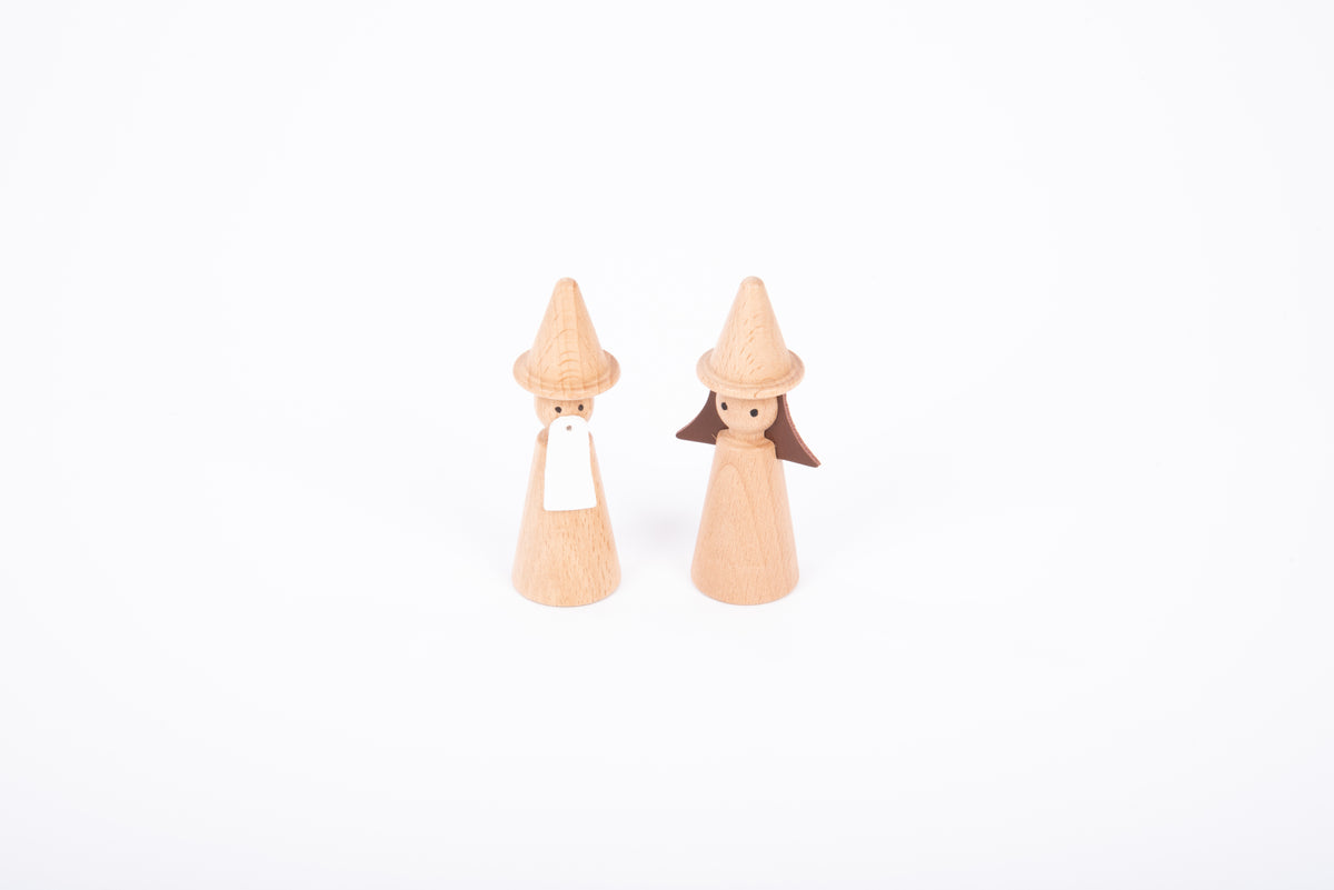 Two wooden wizard figures with cone hats and light wood bodies