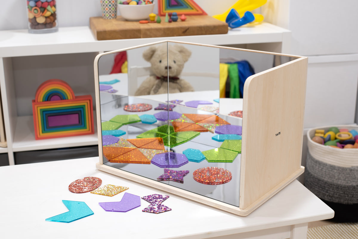 Wooden exploratory mirror with light wood frame and mirrored colorful shapes
