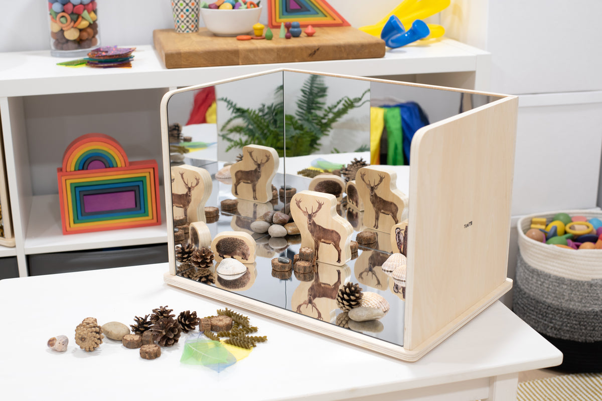 Wooden exploratory mirror with light wood frame and reflective animal play pieces