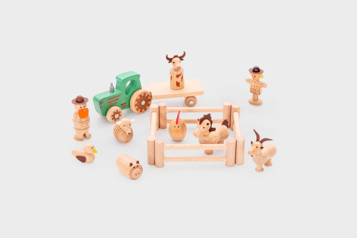 Wooden farm play set with tractor, animal pen and farm figures arranged