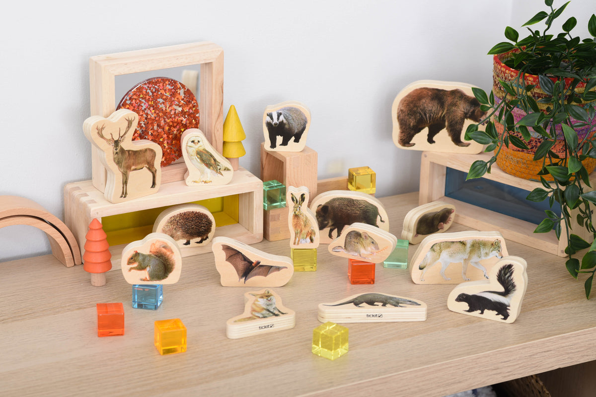 Wooden forest animal blocks arranged on a tabletop with animal wooden cutouts and cube blocks