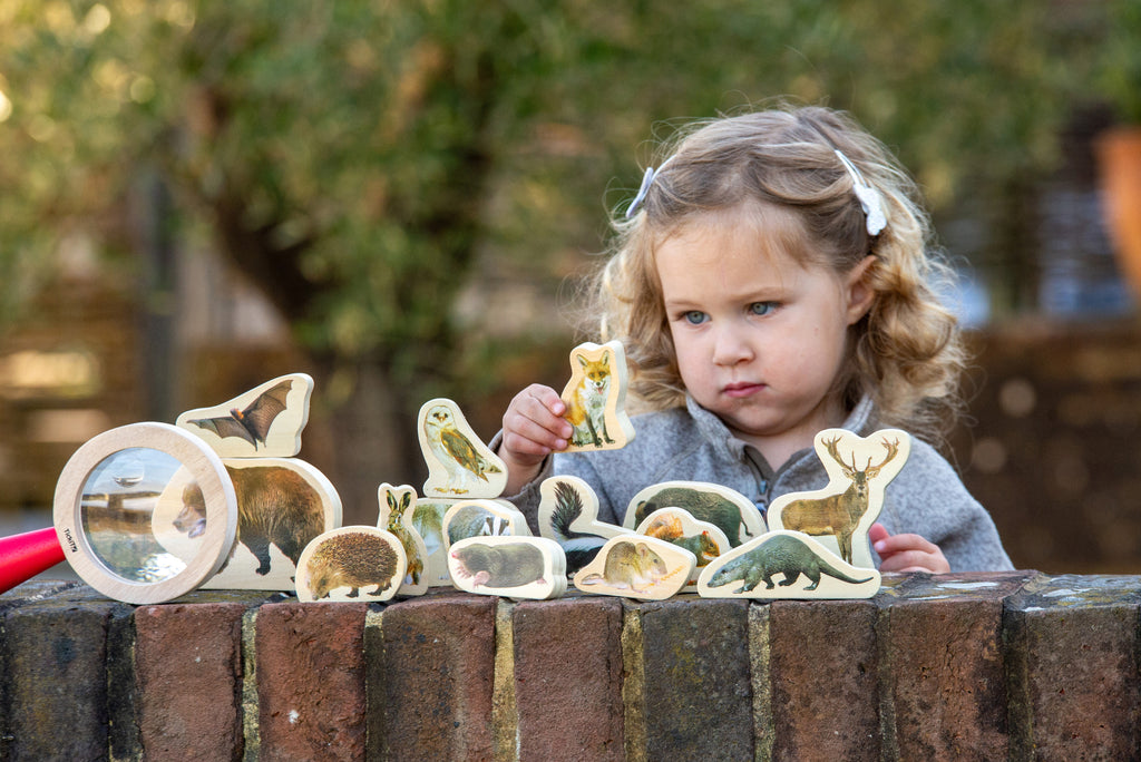 Wooden forest animal blocks with small animal pieces held by a child