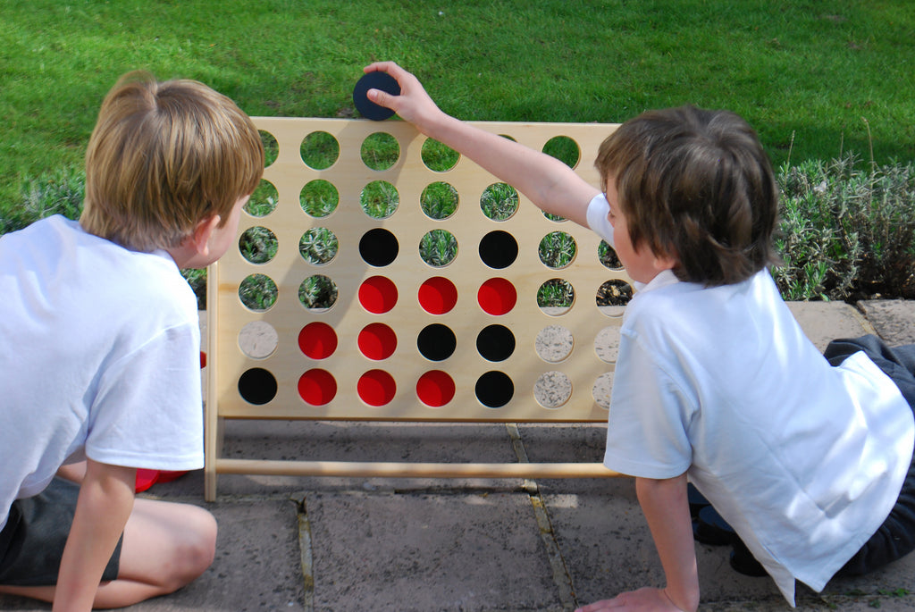 Wooden Connect Four board showing green, red, and black circular openings