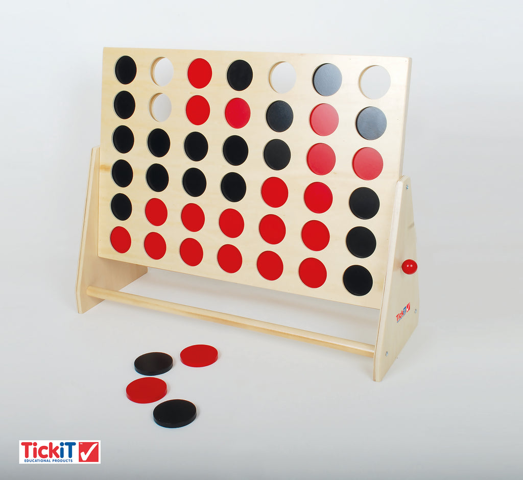 Wooden Connect Four board with red, black, and light discs on table