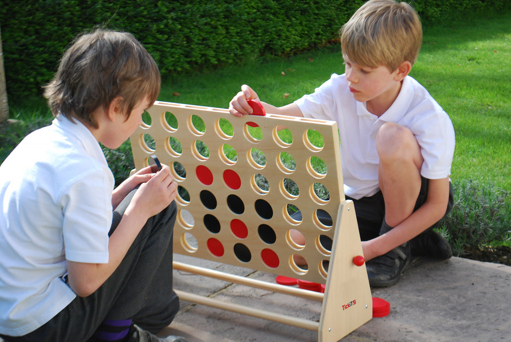 Wooden Connect Four board with circular disc openings and colorful pieces