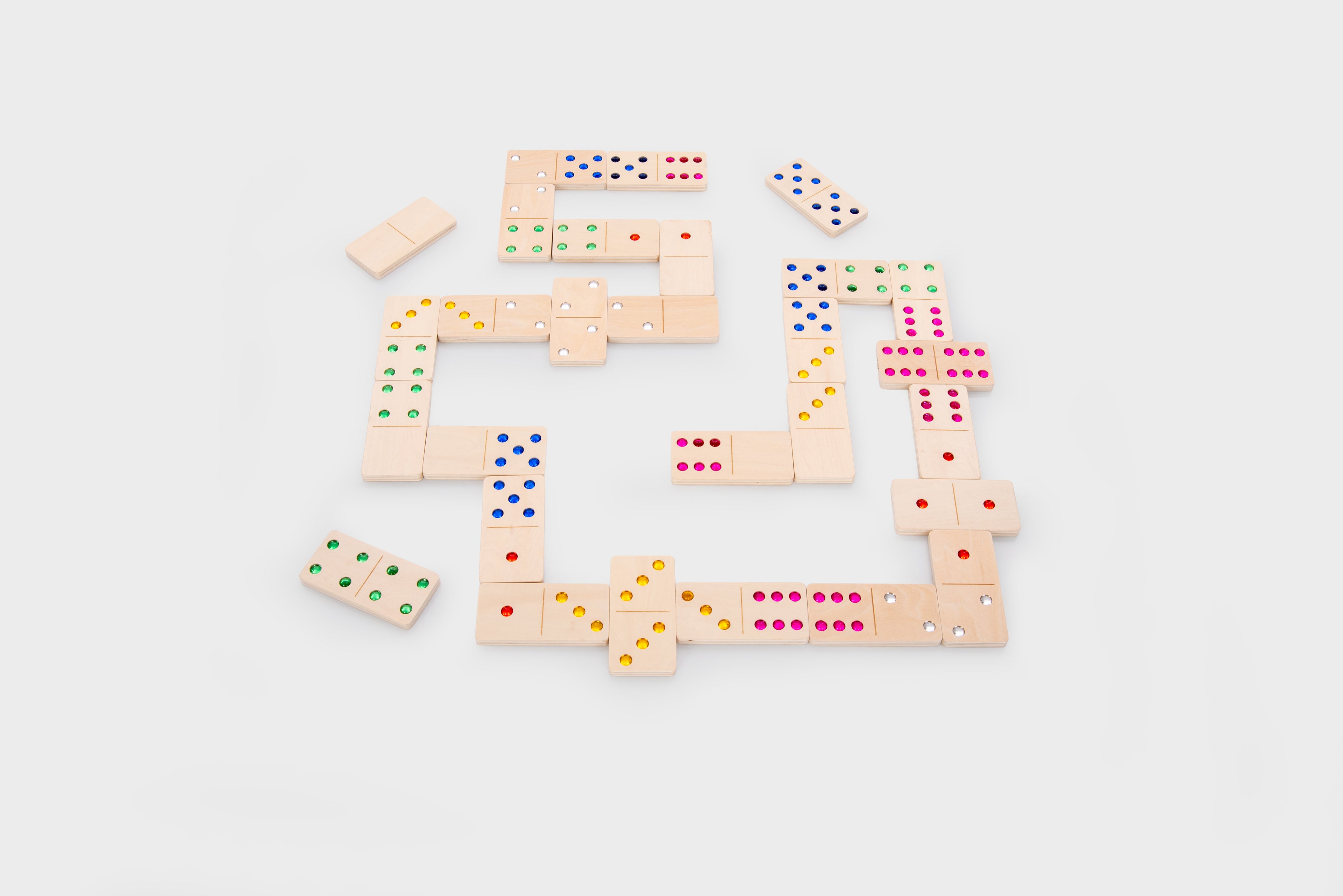 Wooden dominoes arranged in a circular chain with colorful dot pips.