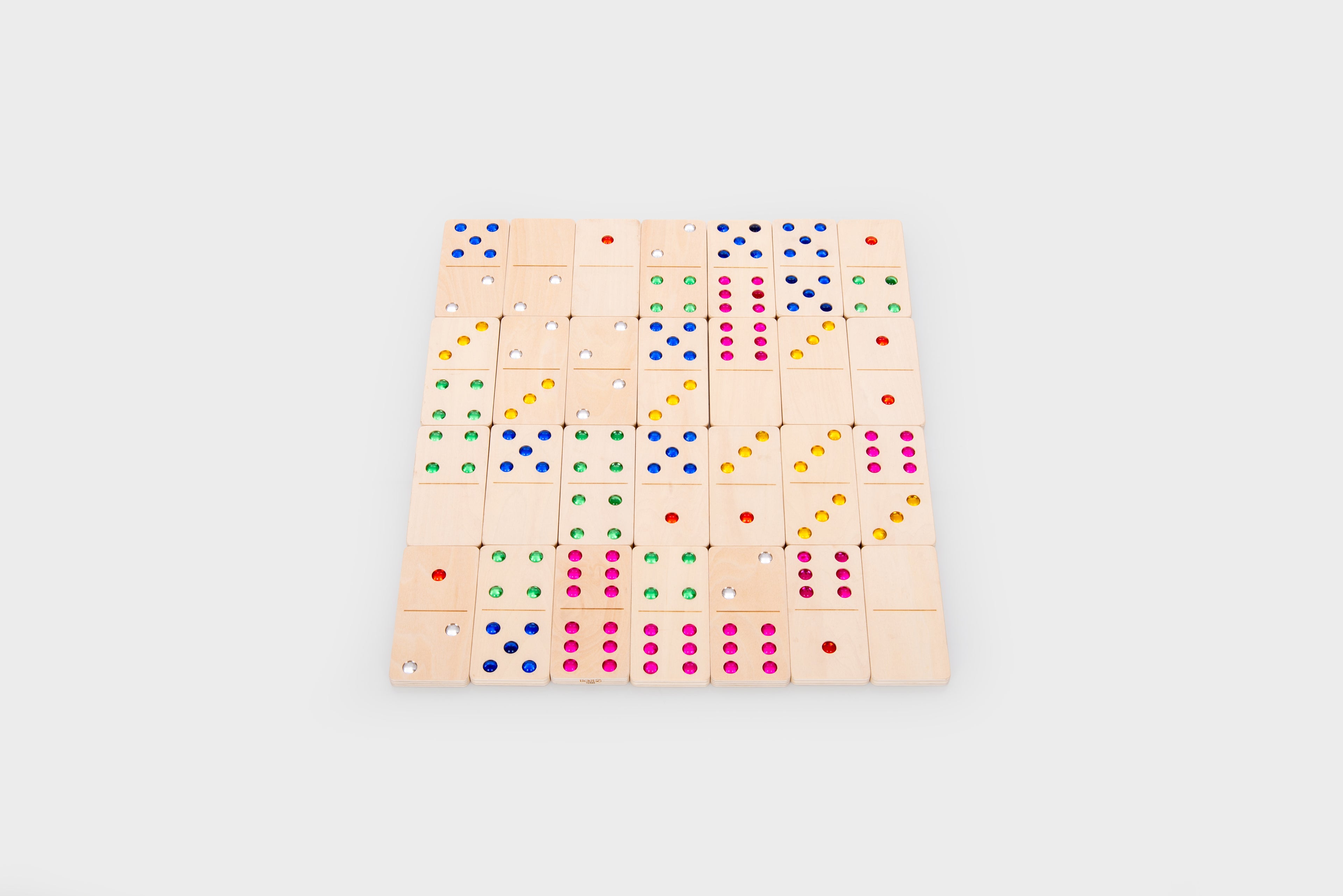 Wooden dominoes laid out in a large square grid, each tile with colored dots.