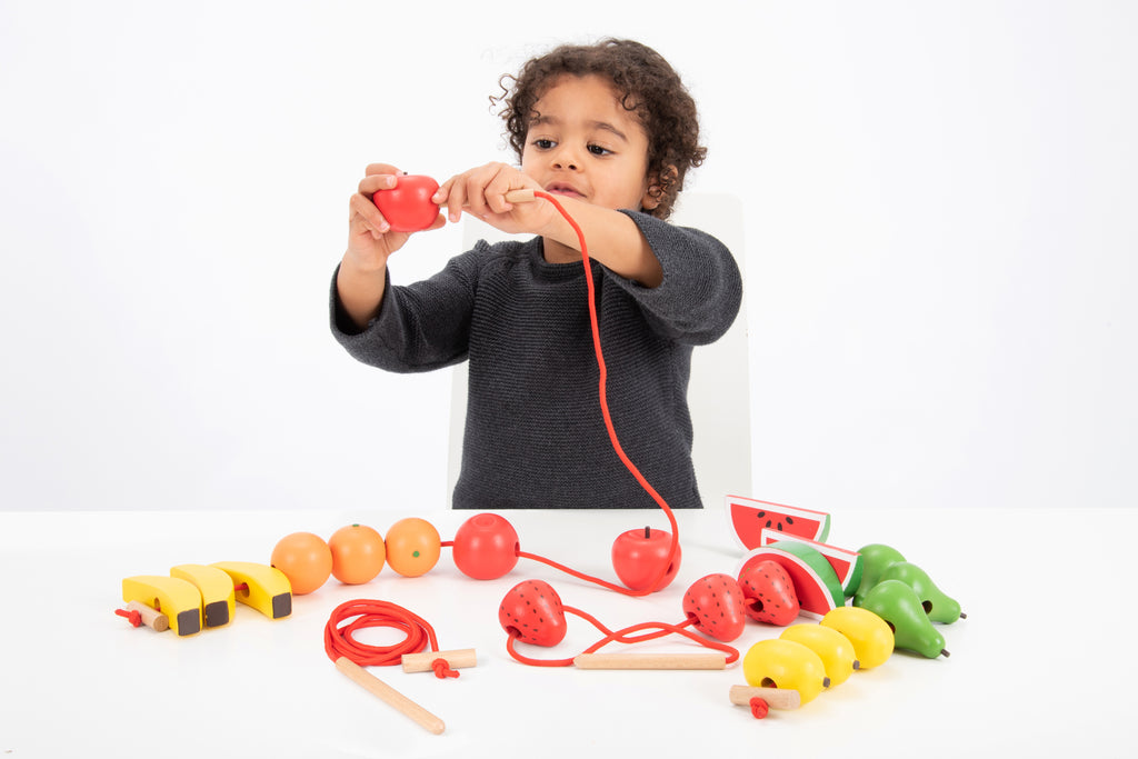 Wooden lacing fruit toy with red cord and colorful wooden pieces for threading